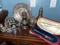 Full lot arranged on wooden surface, includes plate, shakers, casters, dishes, case