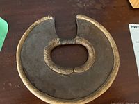 Full top view of round metal tribal plate with wire wrapped ring in center.