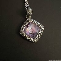 Front view of pendant showing square purple semi-precious stone set in detailed 925 sterling silver frame with studded pattern.