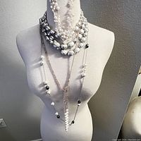 Full front view of 4 layered custom necklaces on a white mannequin torso showing varying bead sizes and colors.