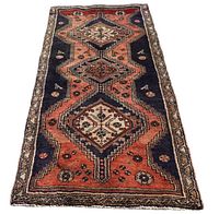 Full view of Persian Zanjan rug showing three central rhombus medallions with detailed geometric patterns in red and black with border