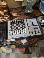 Vintage Schneider electronic chess board with black and white chess pieces on the board, showing the control buttons and branding.