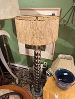 Mid-century chrome floor lamp with a unique textured cream-colored drum shade featuring abstract line patterns.