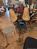 Photo of a mid-century double gooseneck floor lamp with two beige fiberglass conical lampshades showing floral designs and wear.
