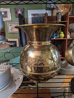 Clear front view of a polished brass spittoon with a wide funnel top and rounded body. The front has an engraving of a Union Pacific train and text below it.
