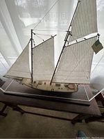 Front view of the schooner model inside plexiglass display case on wooden base