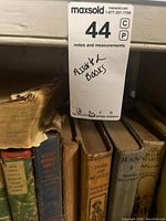 Shelf with assortment of vintage hardcover books showing titles and condition.