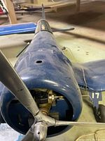 Front view of airplane nose showing three-blade propeller and engine mount