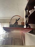 Front view of the burnt orange wooden airboat model with visible propeller and circular metal frame housing the engine