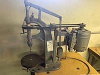 Side angle view of the Pratt & Whitney drill press showing the motor, belt drive, and working table.