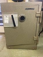 Front exterior view of textured grey steel safe with combination dial and external hinges