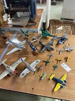 Selected photo displaying the full set of miniature airplane models arranged on a wooden surface, highlighting various different styles and sizes.
