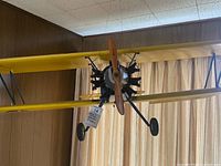 Front view of yellow biplane showing radial engine, wooden propeller, landing gear