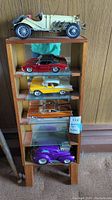 Full view of wooden shelf with five model cars displayed on each shelf.