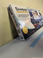 Box of Samson Tugboat model kit showing product branding and illustration of assembled tugboat on water.