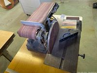 Photo of the Sears Craftsman power sander showing the belt and disc sanding surfaces mounted on a wooden table.