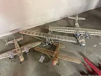 Four model airplanes displayed on the floor, showing their size and design details
