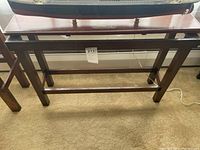 Front view of the wooden stand frame without top showing legs and supports