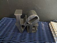 Front angle photo of aluminum LOVE sculpture showing the distinct tilted 'O'. Matte metallic grey finish with minimal surface wear.