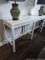 Front angle showing the full console table with two green lamps on top, highlighting the white painted finish and overall condition.