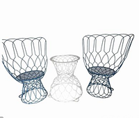 Two blue wire high back chairs and one white wire table base photographed against white background.