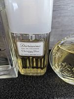 Close up of Diorissimo Eau de Cologne by Christian Dior 50ml bottle with white cap, approx 3/4 full yellow liquid inside