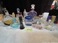 Group view of the perfume bottles showing variety of shapes, sizes and colors with some containing liquid and some empty.