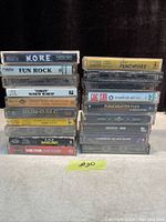 Front view of two stacks of vintage rap and hip-hop cassette tapes in plastic cases showing titles and cover labels on the shelf.