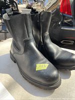 Pair of black men's boots angled side and front view with visible size 11 and 'like new' condition.