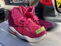 Pair of pink Nike Zoom Hyperdunk running shoes shown from the front and side angle with visible Nike swoosh on midsole, laces tied, and minor wear on soles and fabric.