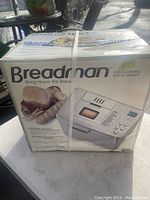 Photo of Breadman bread maker box showing front with text and image of machine and bread loaves.