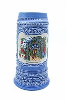 Full view of blue ceramic beer stein with decorative relief patterns and colorful central design of a man in traditional Bavarian attire with surrounding flowers and mountains.