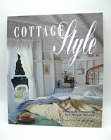 Front cover of the Cottage Style book showing a cozy cottage bedroom interior with a metal bed frame, bedding, and window.