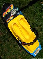 Top view of the HO Sports Edge 720 knee board showing the yellow molded seat, blue base, and strap with branding.