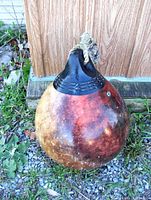Full view of large round inflatable anchor buoy ball showing discoloration and wear on rubber surface with rope attached.