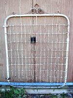 Front view of entire wrought iron garden gate showing rectangular frame and wire grid.