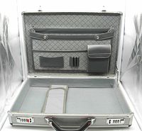Open view of metallic briefcase showing interior compartments and combination locks on front edge.