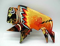 Photo front view of wooden hand-painted bison sculpture showing bright colors and stylized pattern