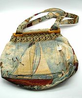 Front view of the fabric jacquard sailing shoulder bag showing sailboat design, wooden frame, and shoulder strap.