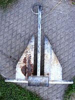Front view of the galvanized steel folding marine anchor showing rust spots and wear.