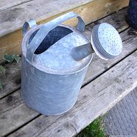 Photo showing the watering can from a side angle, highlighting the double handle and spout.