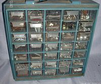 Front view of blue plastic 35-drawer storage cabinet with transparent drawers showing metal fasteners inside