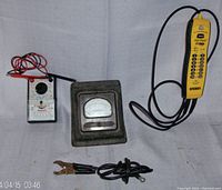 Overview showing all three devices: Simpson analog milliamperes meter with clamp probes, Sperry yellow handheld voltage tester, Mastercraft multimeter with red and black probes.