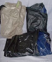 Three deflated air mattresses in beige, black, and blue color lying flat on white cloth background.