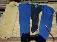 Eight inflatable flotation bags laid flat on a wooden surface, showing yellow, blue, and black colors with some air valves visible. Some wear and dirt marks apparent.