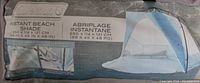 Photo of the Coleman Instant Beach Shade packaging showing product name, size, features, and an image of the assembled shade.