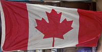 Photo of the large Canadian flag with red maple leaf in center, red vertical bands on sides