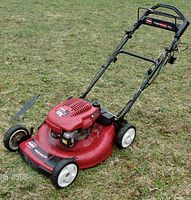 Front-left view showing red steel deck, white wheels and mower layout