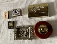 Vintage smoking accessory collection including redwood lighter, metal ashtray, Export 'A' Smooth tin box, and matchboxes with holder.