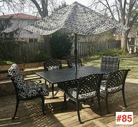 Full set on deck showing table, umbrella, and six chairs
